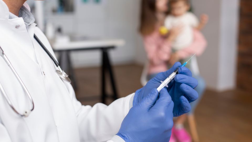 male-pediatrician-administering-vaccine-his-office