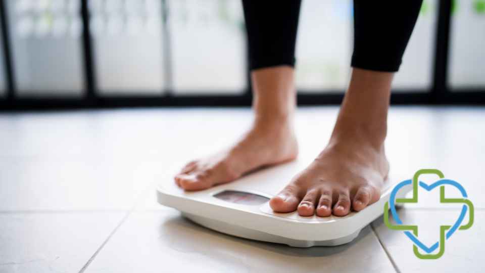 person in bare feet and black leggings standing on scales