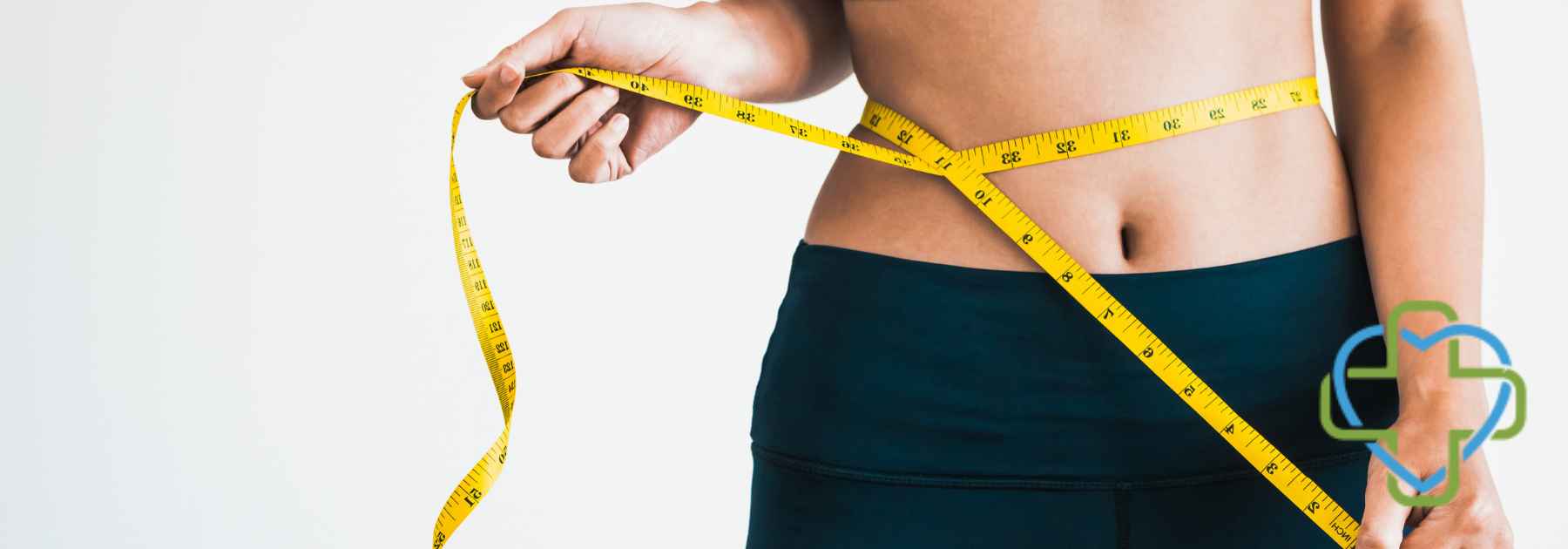 woman in dark workout gear measuring waist