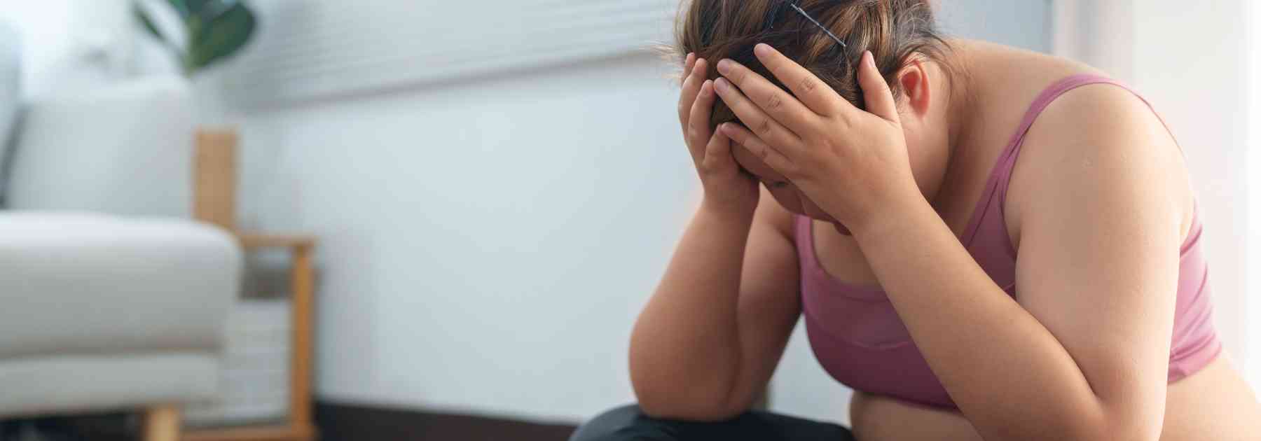 overweight woman putting her head in her hands