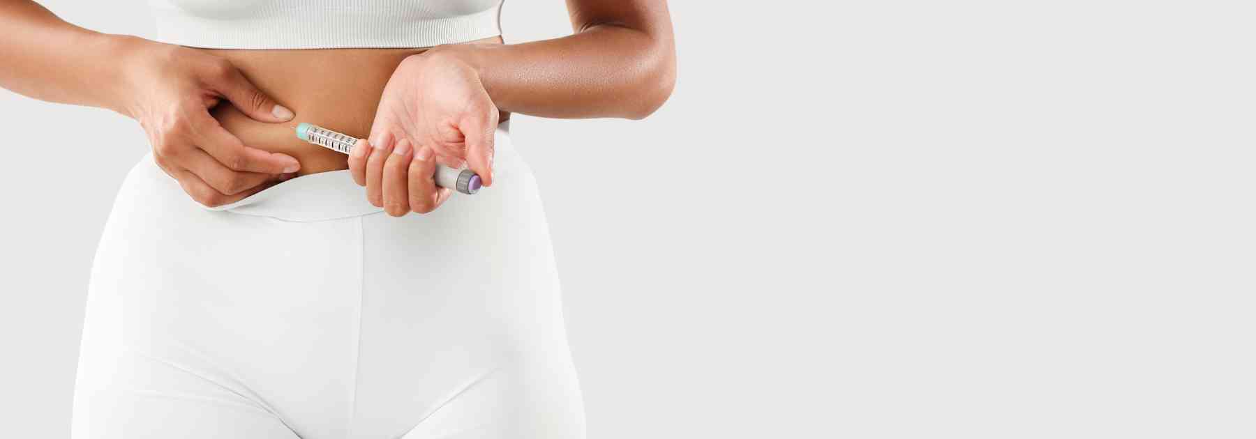 woman wearing white holding weight loss injection