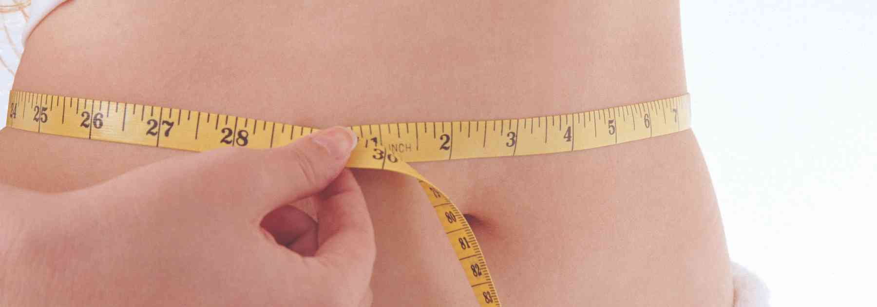 person measuring their waist
