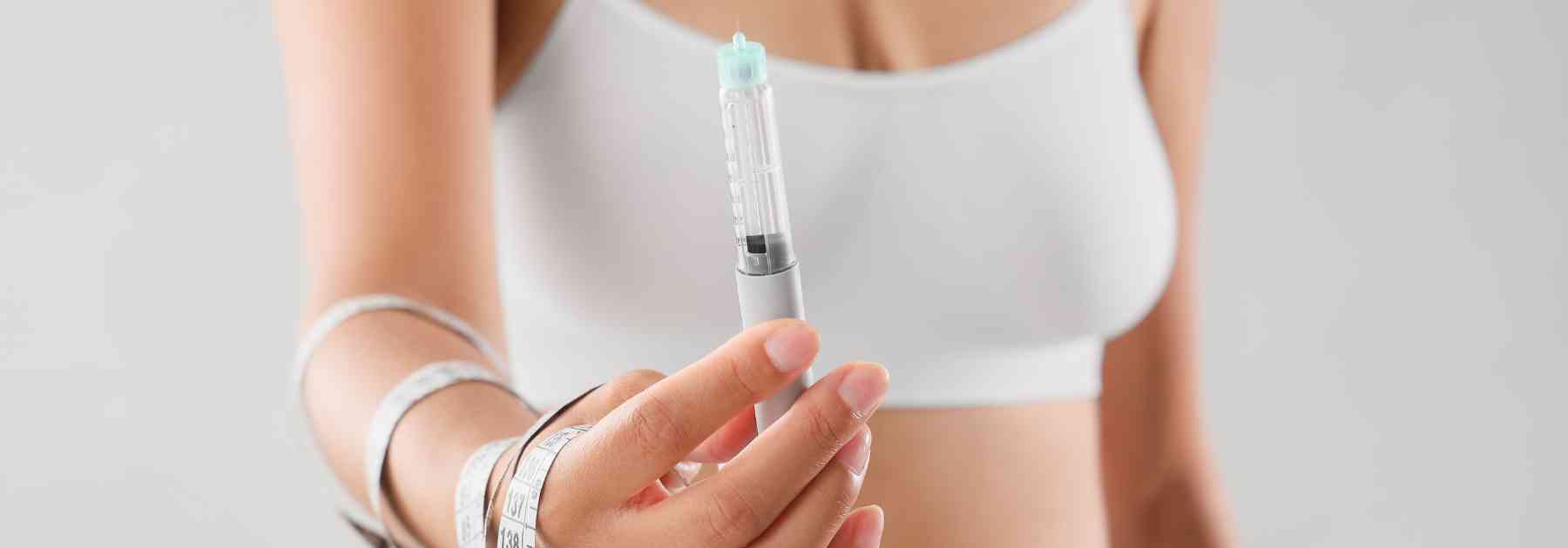 woman wearing white holding weight loss injection