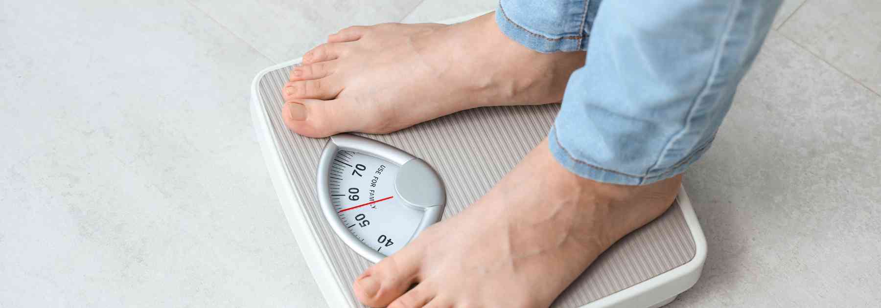 person wearing jeans standing on scales