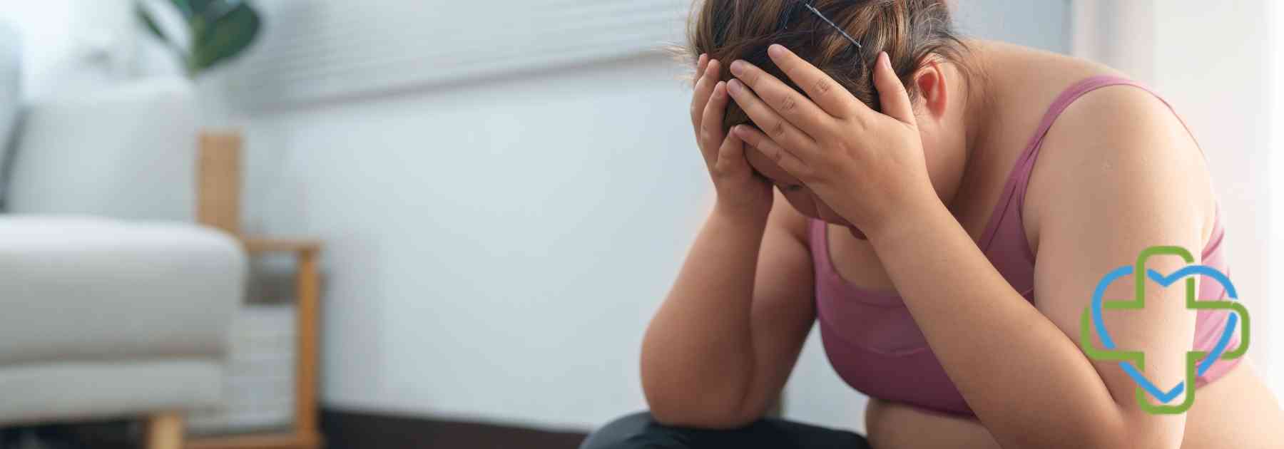 overweight woman putting her head in her hands