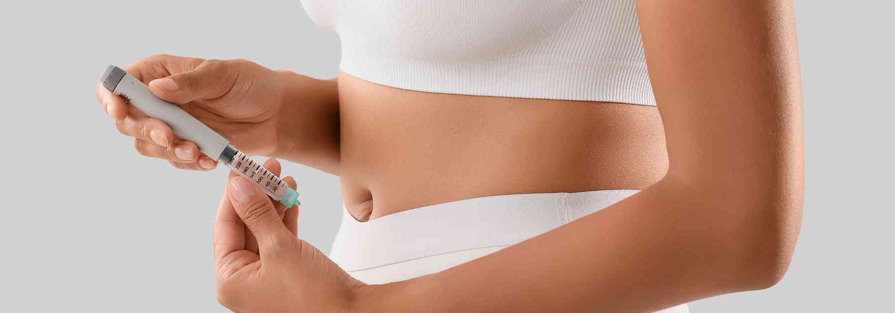 woman in white workout gear holding weight loss injection