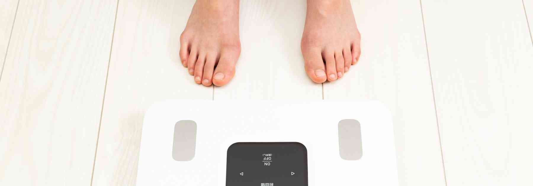person in bare feet standing in front of scales