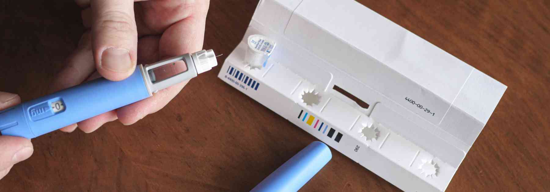 person removing weight loss injection from packaging