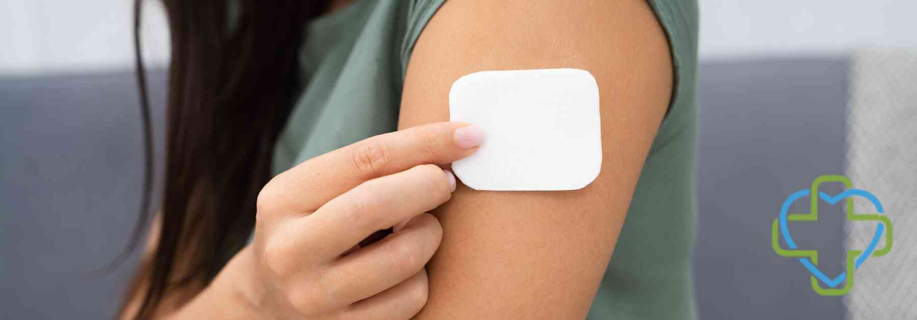 young woman placing white patch on her arm