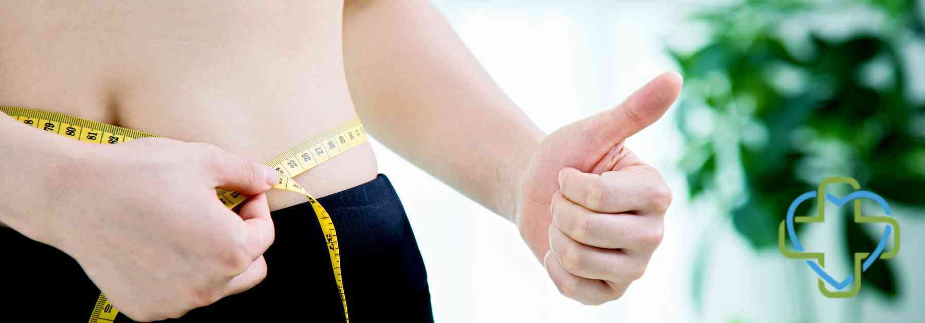 person measuring their waist giving a thumbs up