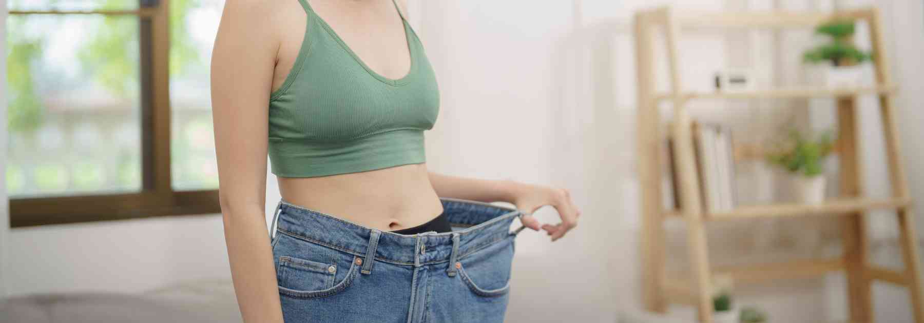 young woman in green crop top wearing jeans too big