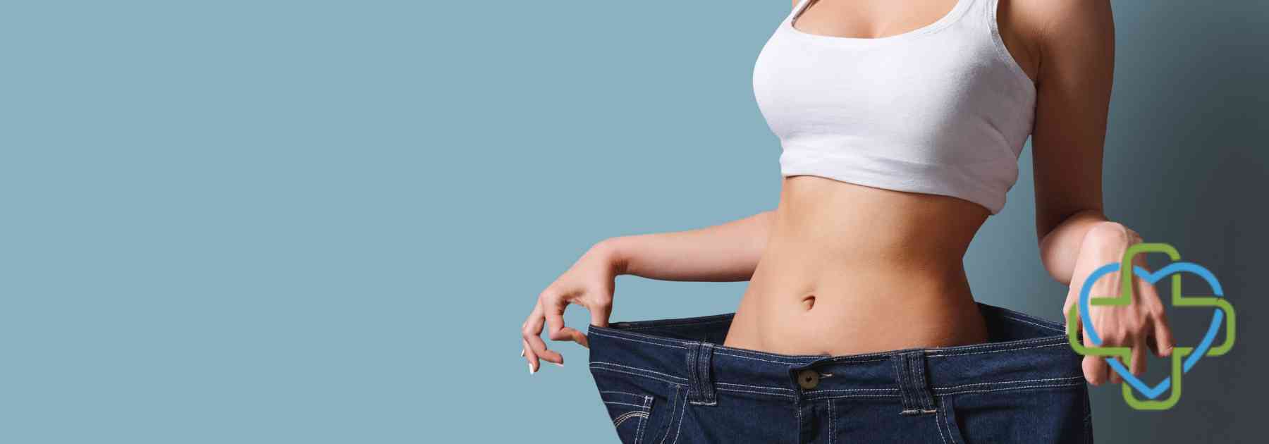 woman in white crop top wearing jeans too big on blue background