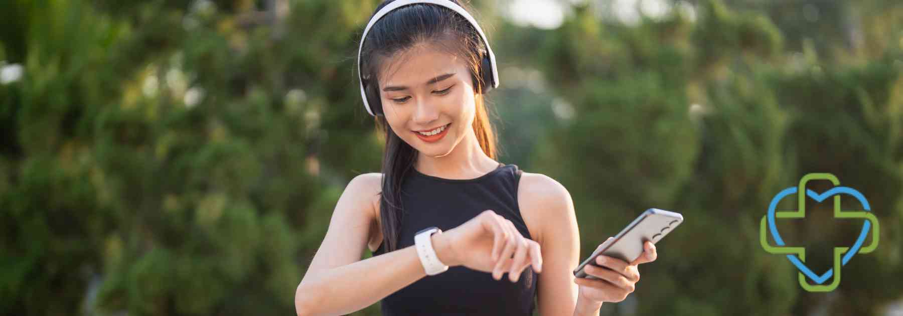 young woman wearing headphones checking smart watch smiling