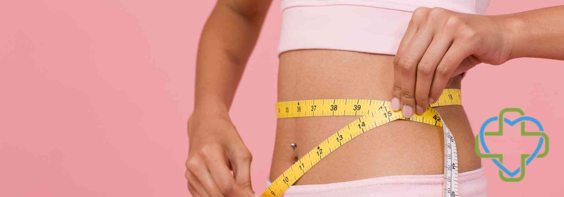 woman in pink workout gear measuring waist