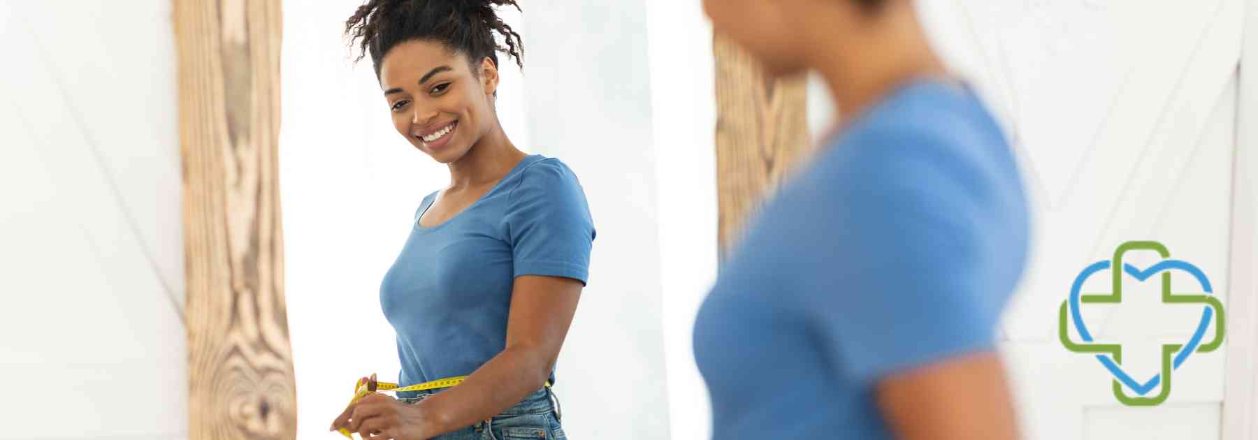 woman smiling looking in mirror measuring waist