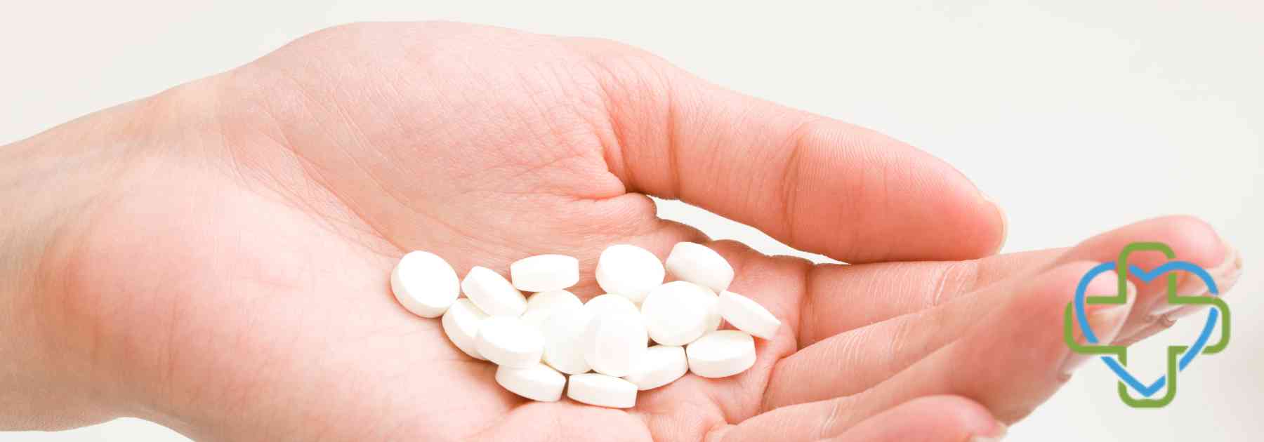 person holding white pills
