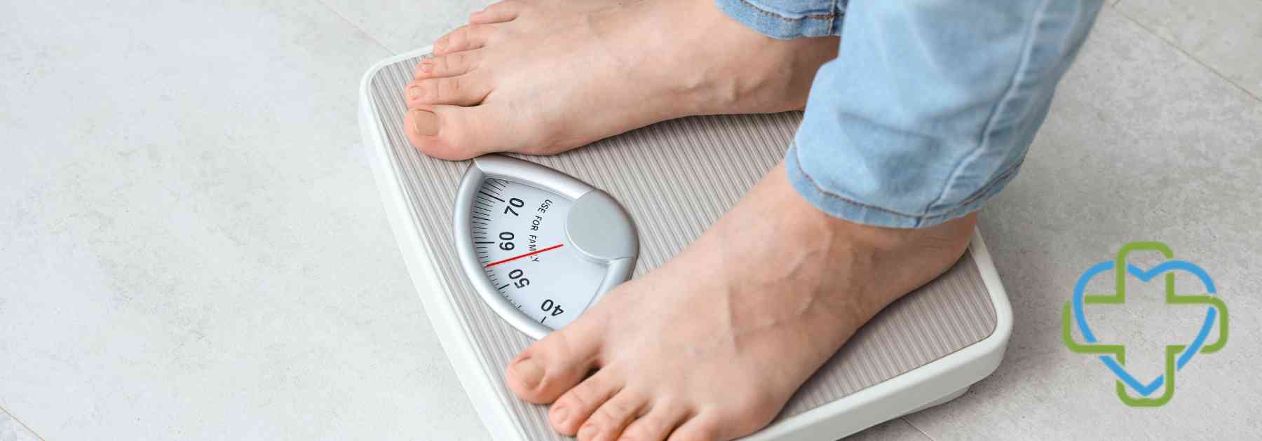 person in bare feet and jeans standing on scales