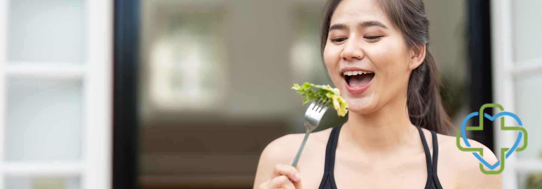 young woman eating lettuce leaf with fork