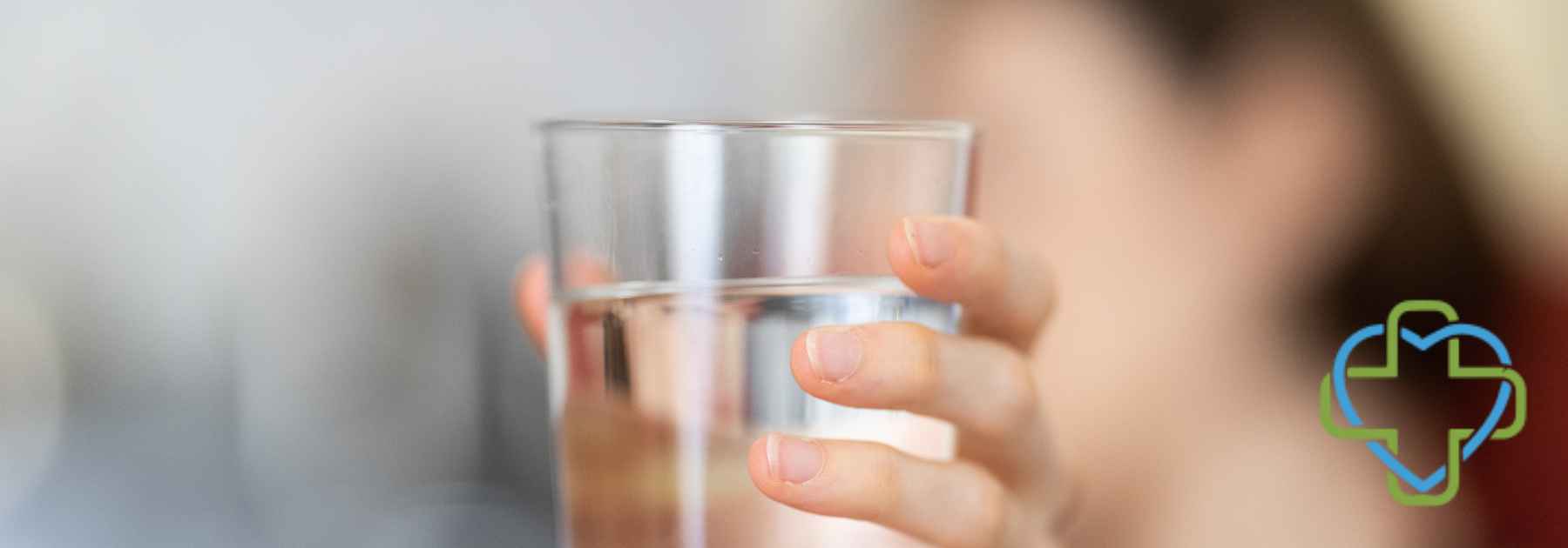 person holding glass of water close to camera
