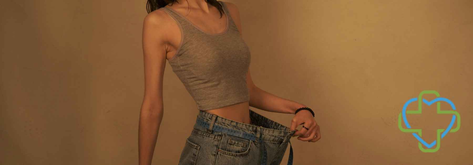 woman wearing jeans too big on dark orange background