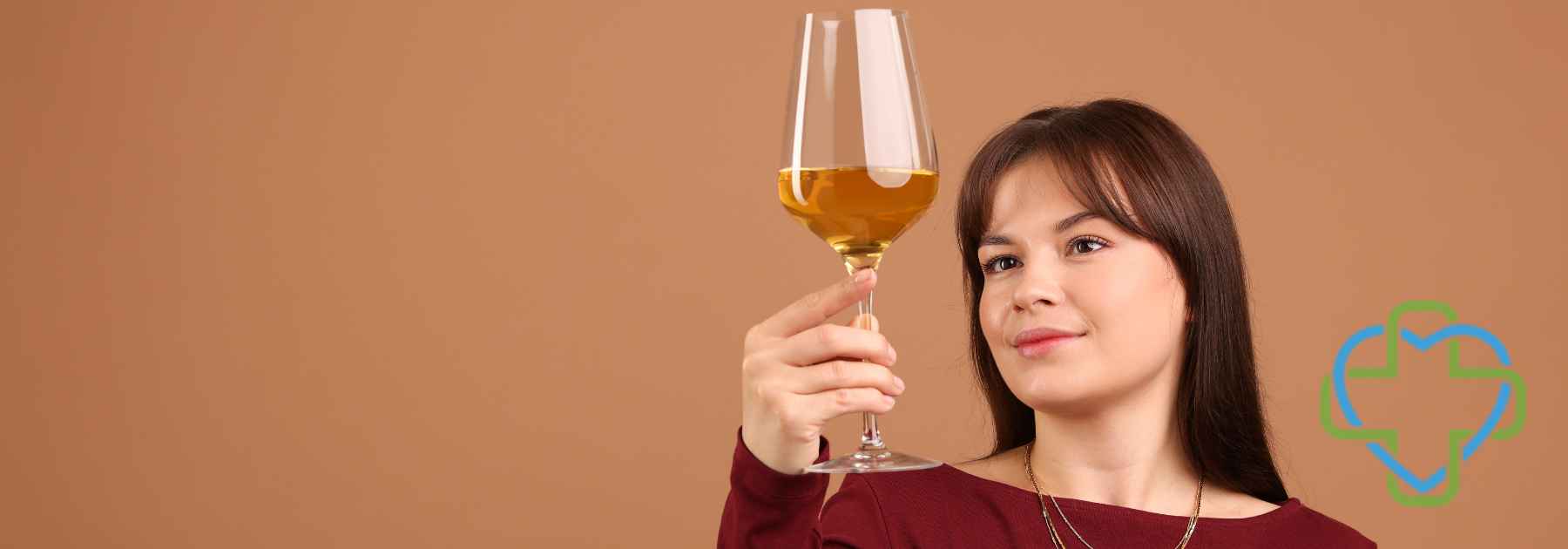 young woman in red shirt holding glass of wine on orange background