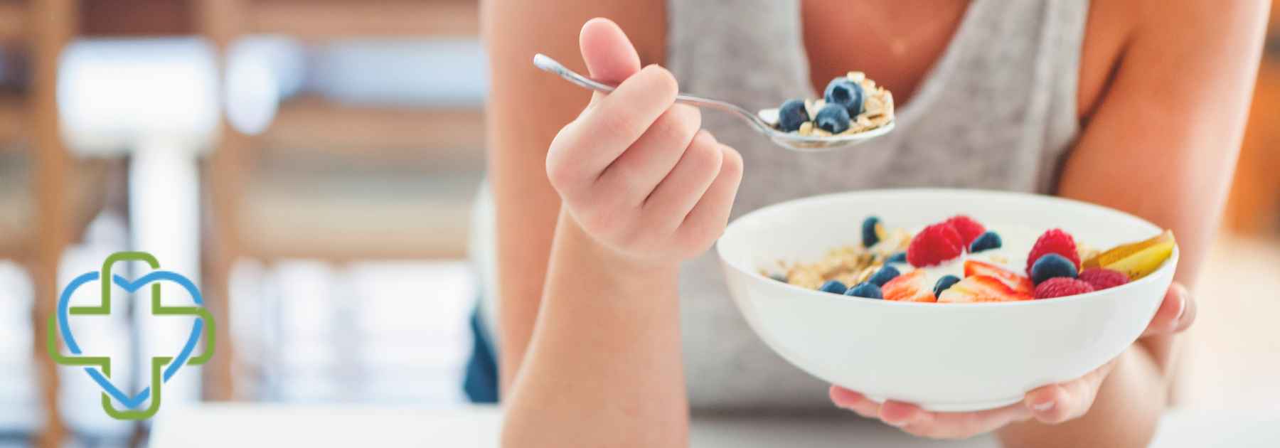 woman eating berries from bowl with spoon