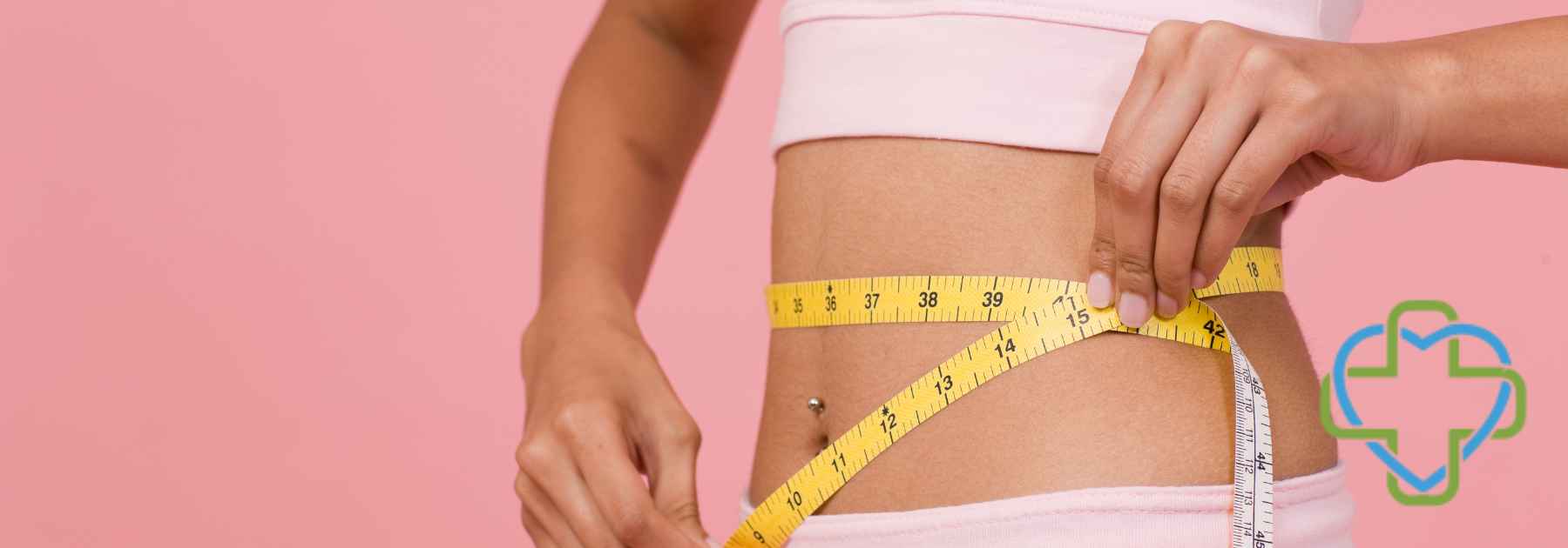 woman in workout gear measuring waist on pink background